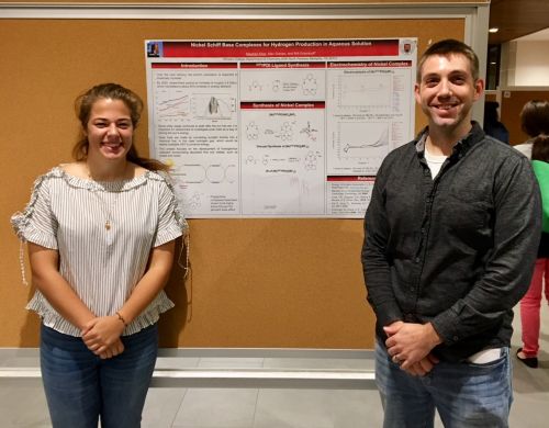 a student and a professor in front of a research poster