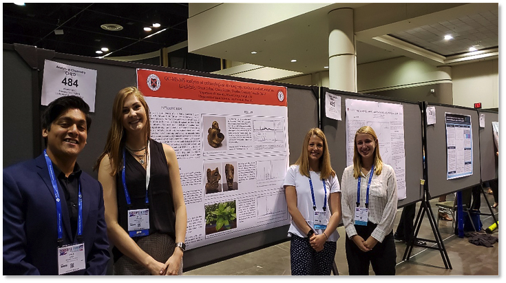 one male and three female students stand in front of a poster presentation