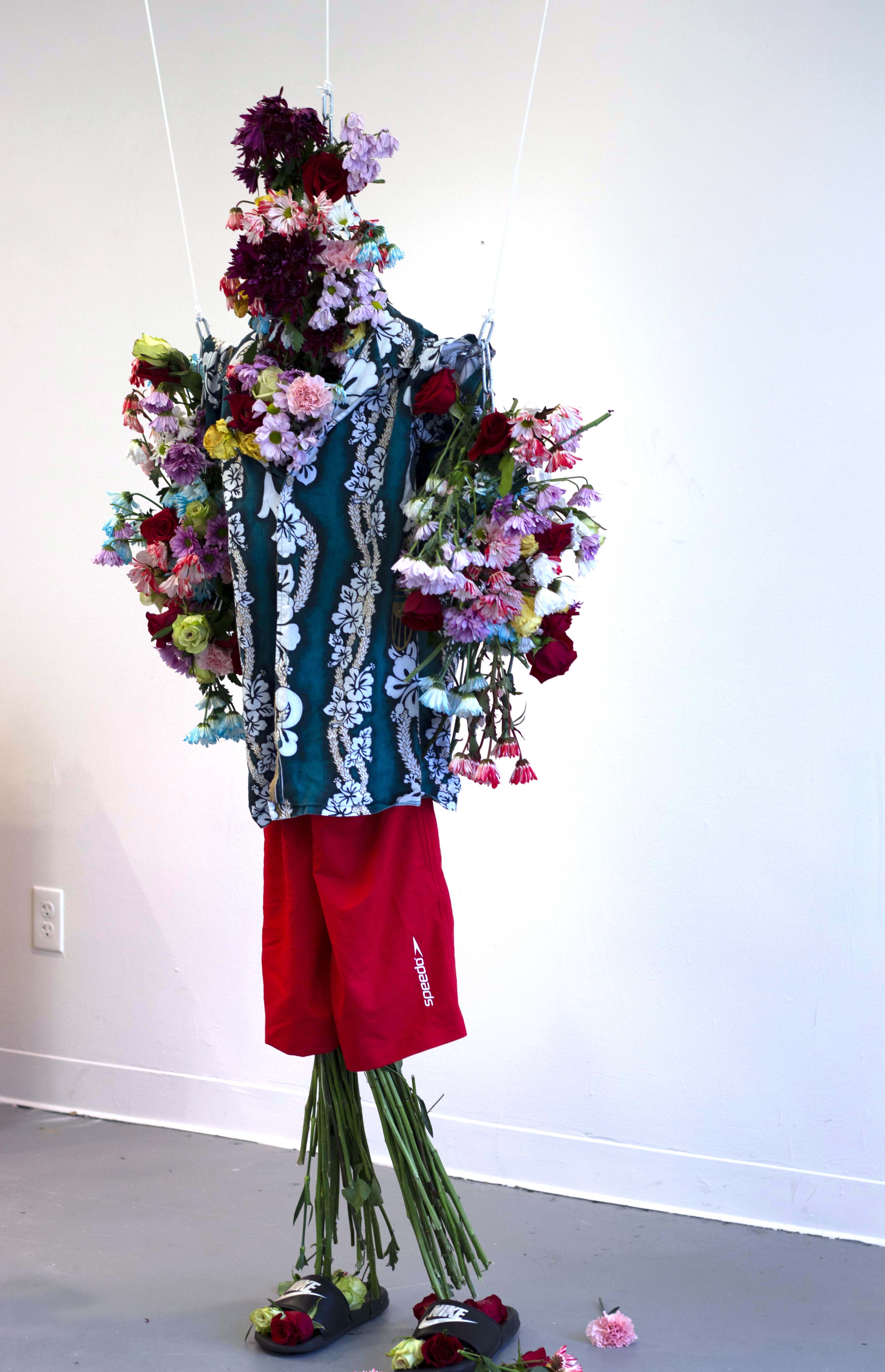 A sculpture made of flowers and clothing.