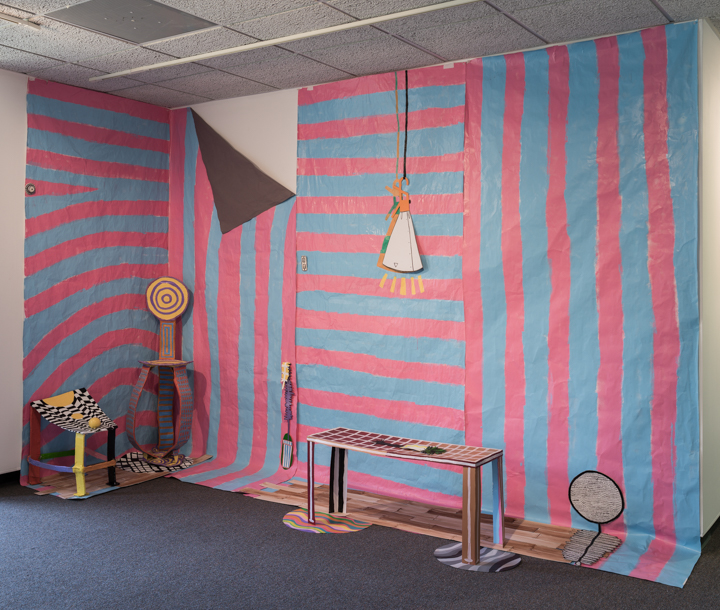 Painted paper installation with with wooden sculpture. 