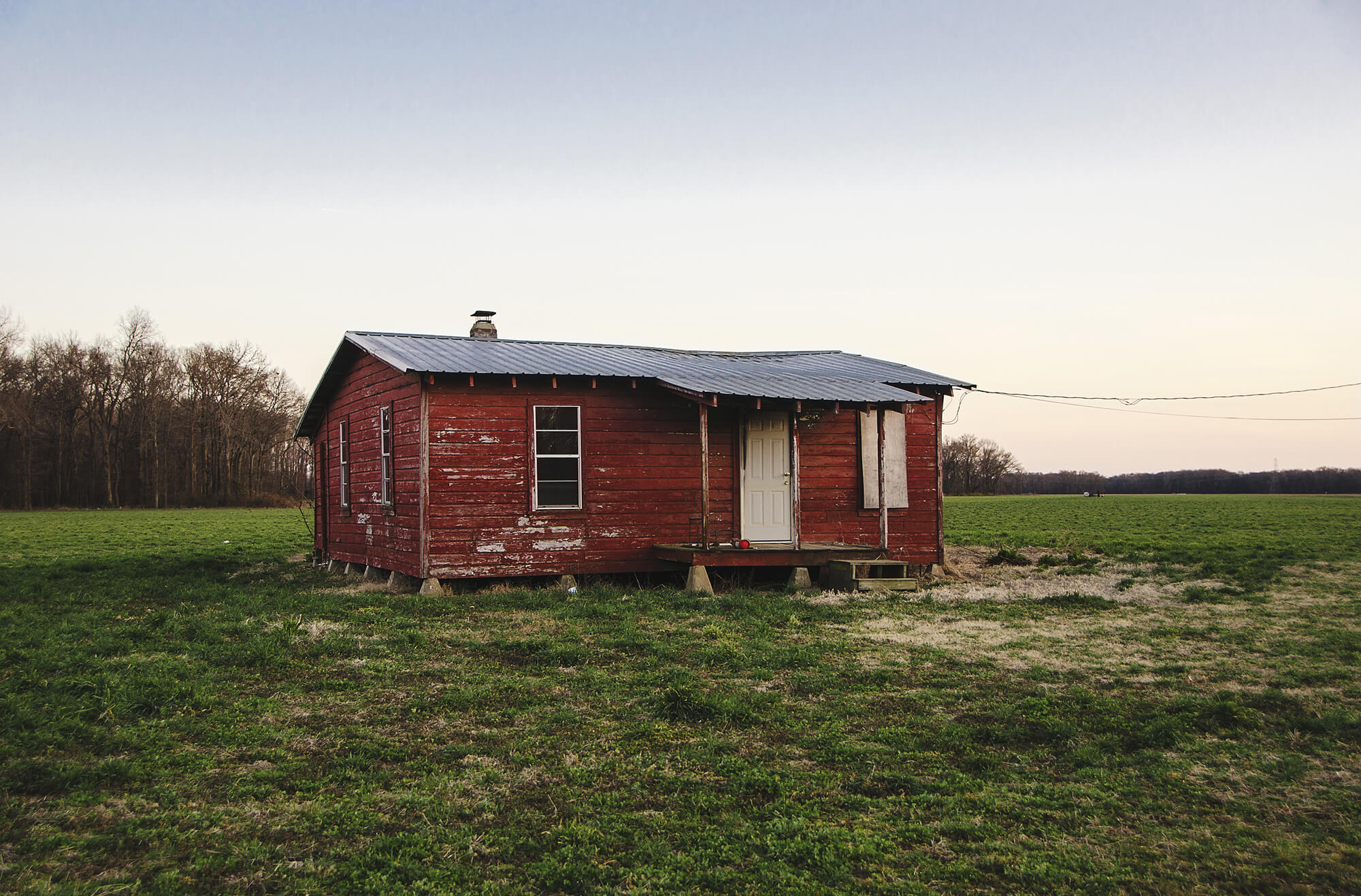 a photo of a red house in a field