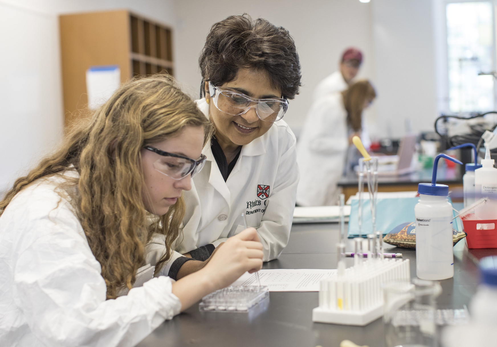 a female professor helps a student in a lab