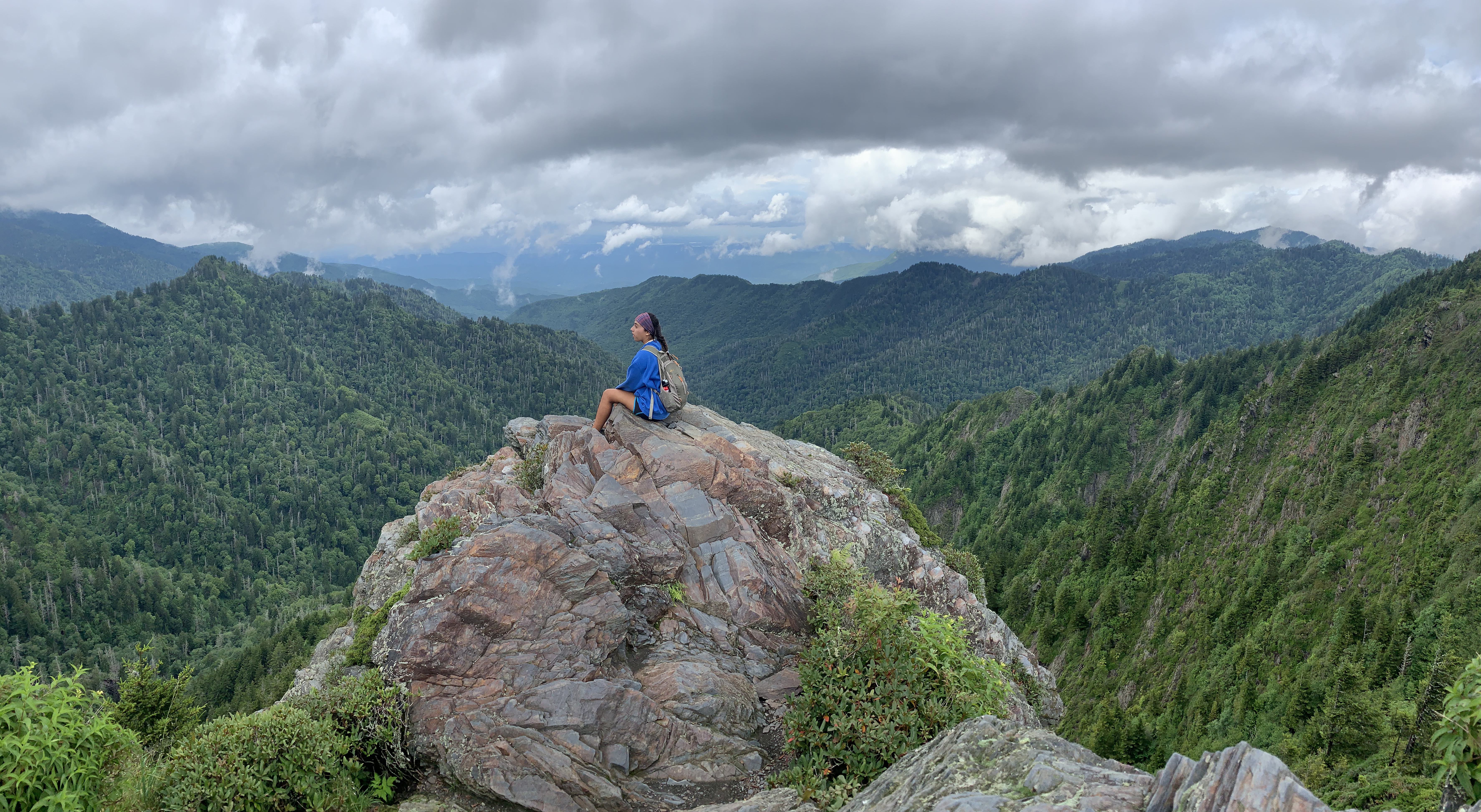 a girl on a boulder in the mountains