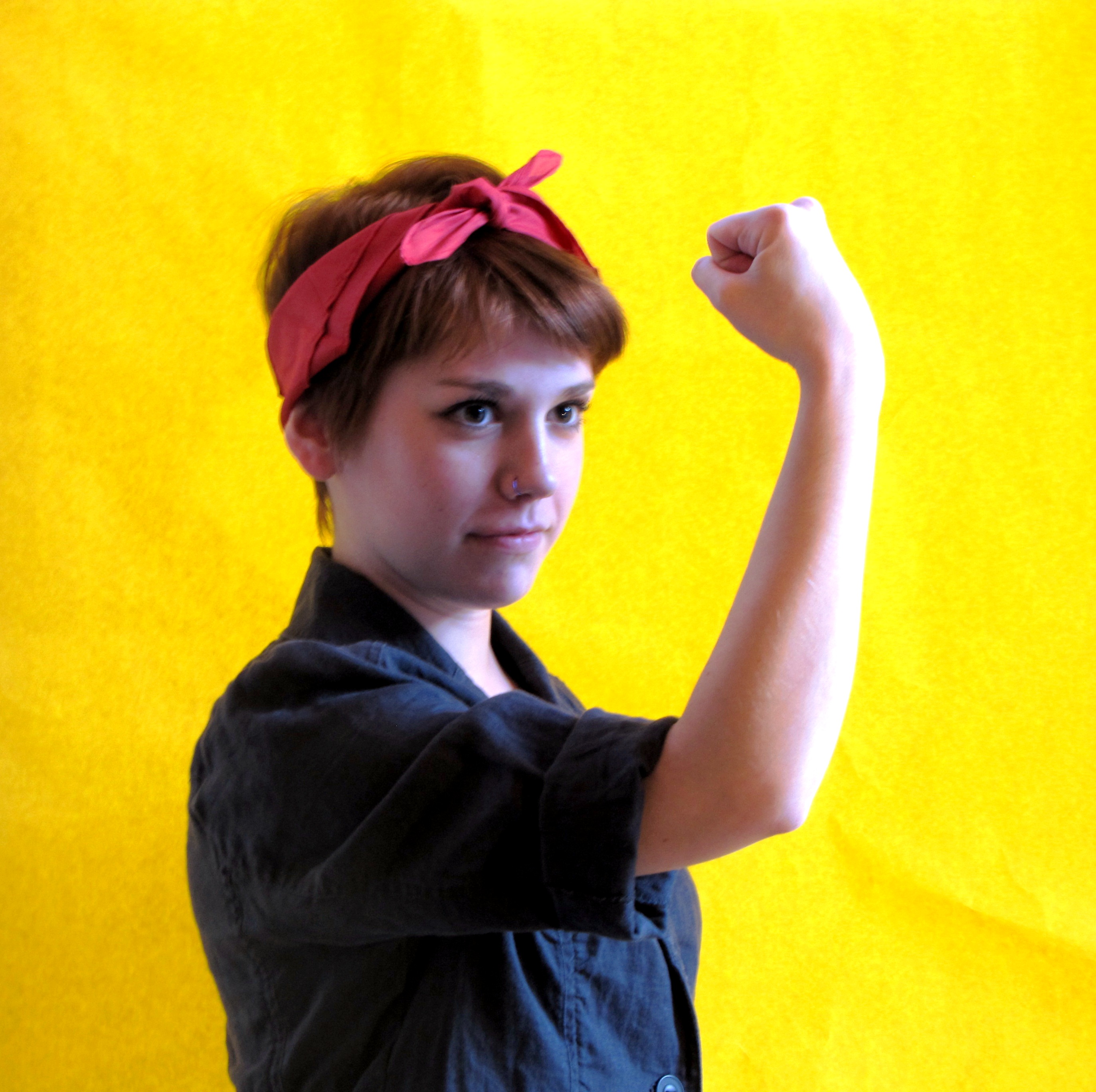 A female student photographed as Rosie the Riveter