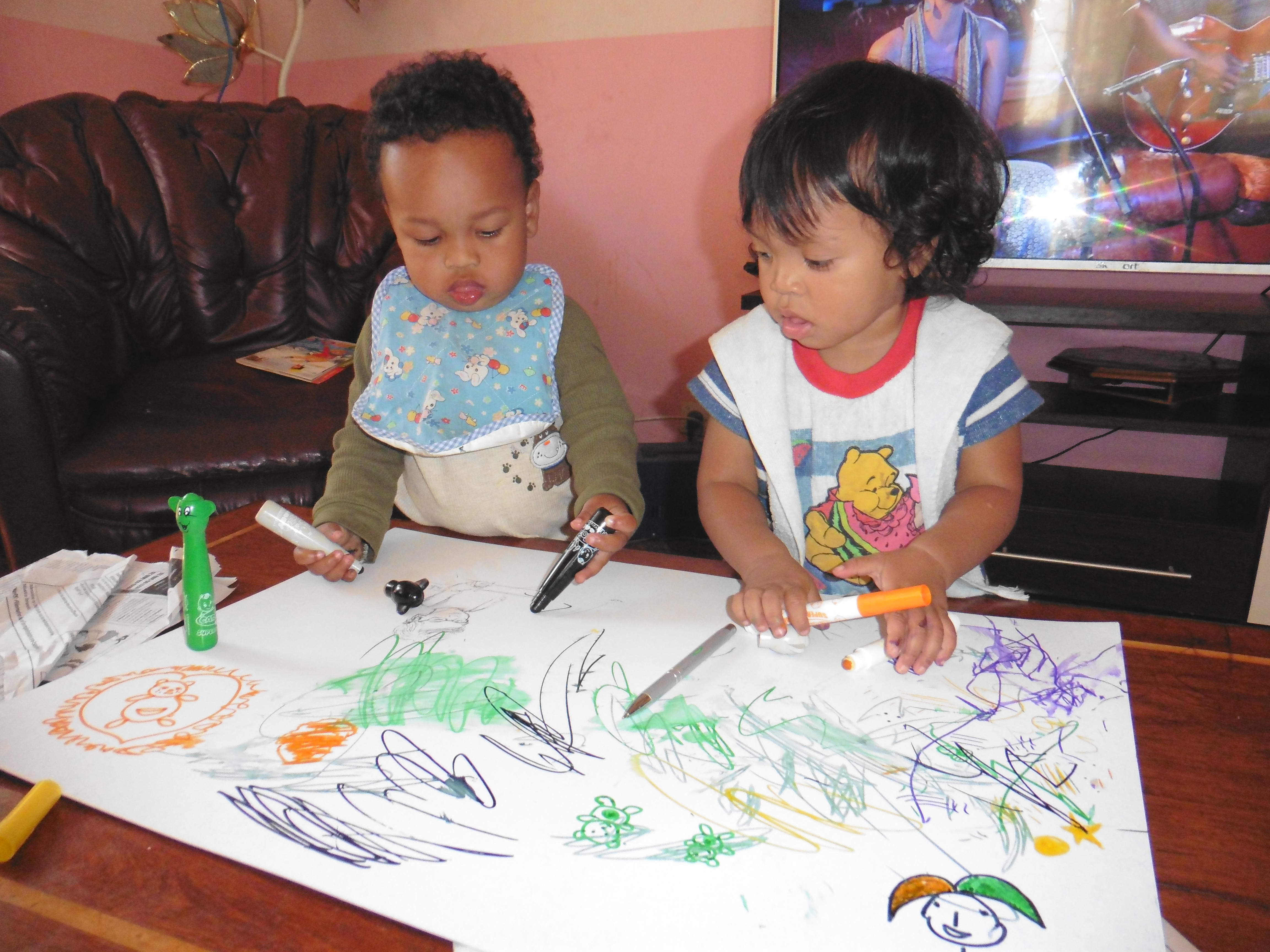 A girl and a boy drawing with markers together. 