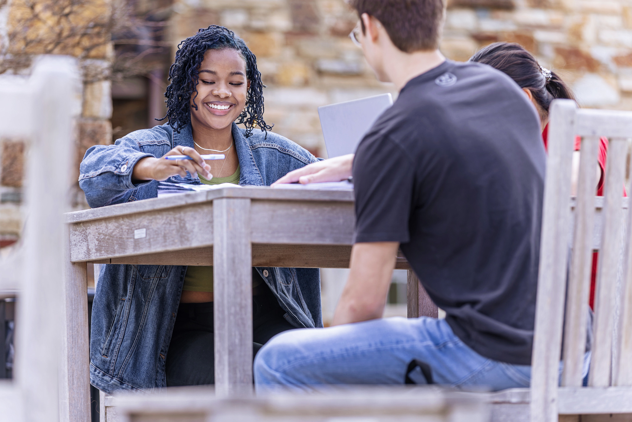 Two students talking at a table outside