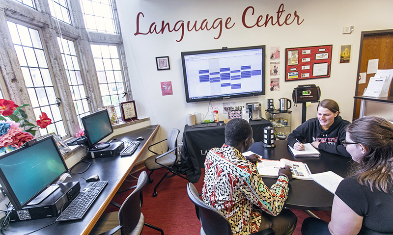 a professor and students at a table in the Language Center