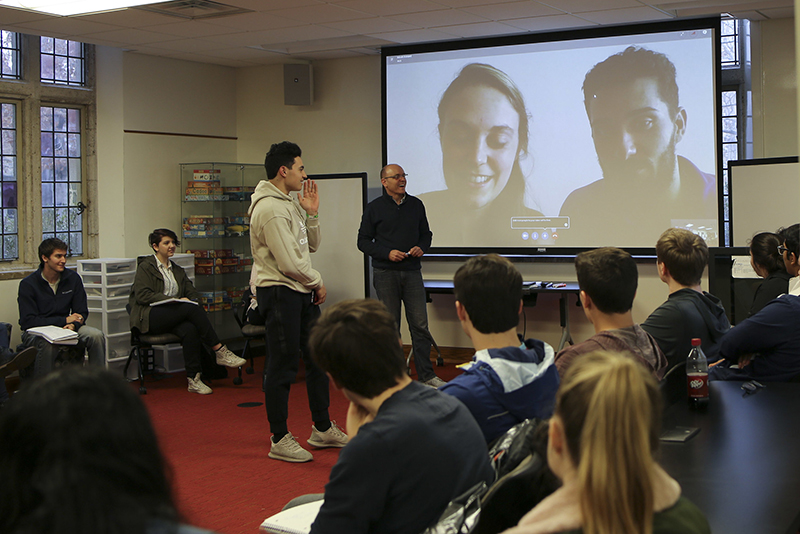 a professor and student in front of a large screen