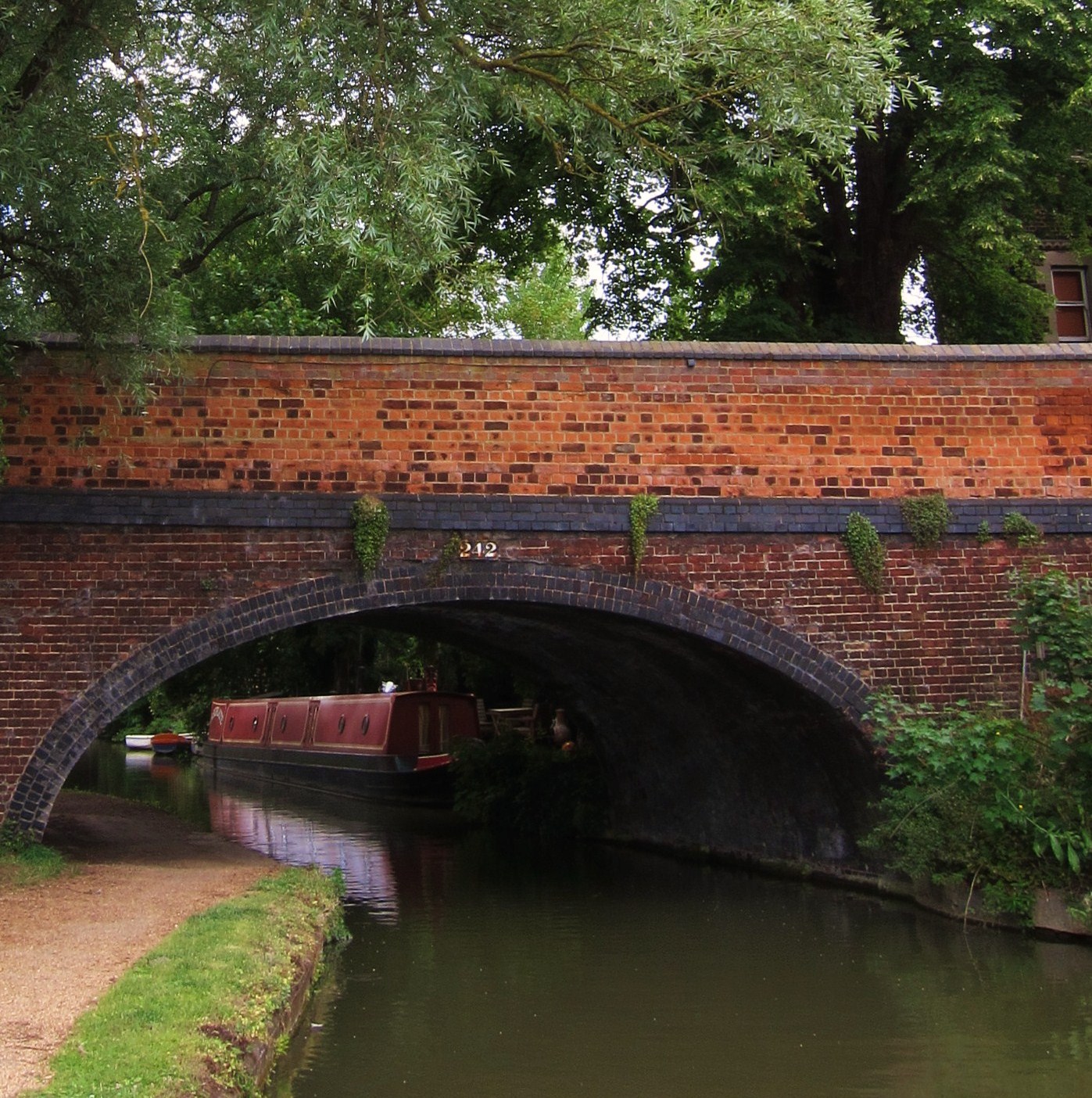 A red brick bridge over a small river