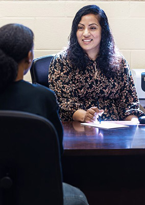 a female professor  talks to a student in her office