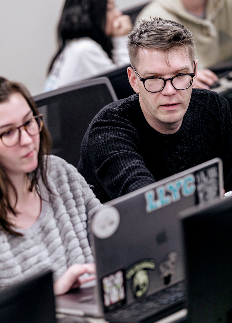 a professor helps a student at a computer