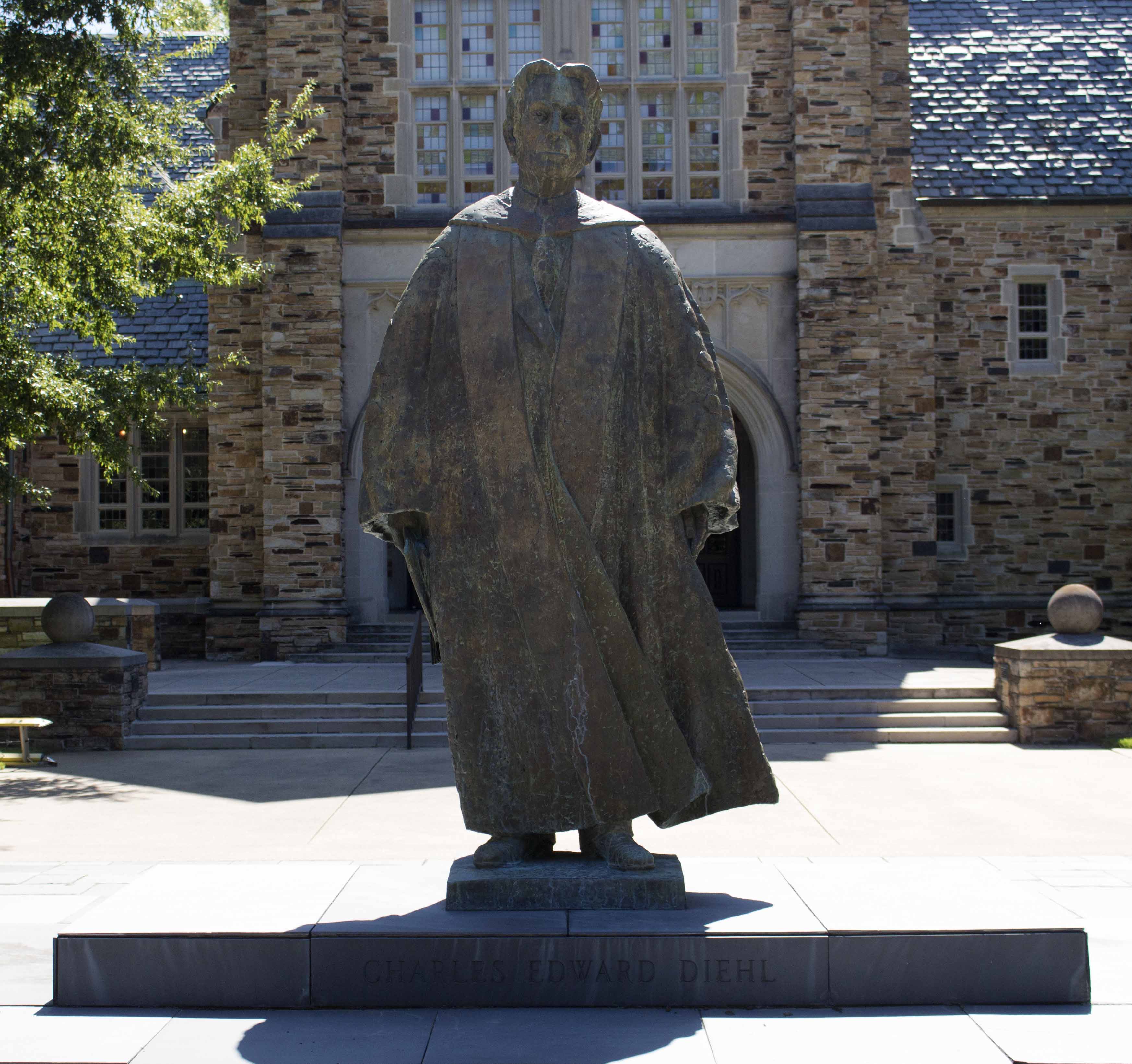 This is a large outdoor sculpture of Charles Edward Diehl wearing regalia and holding something in his right hand. 