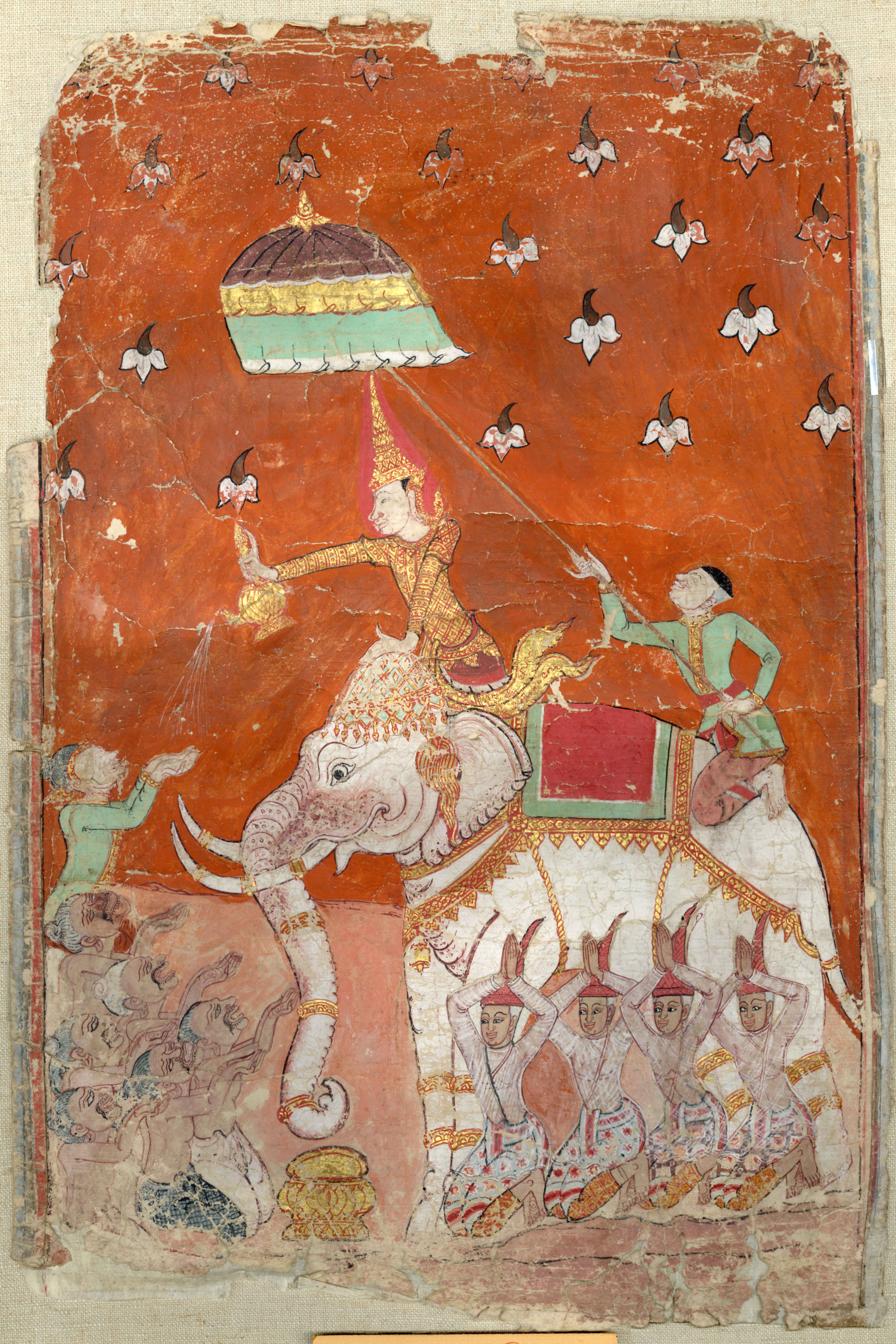 Figure in gold attire sits on an elephant. A figure sitting on the back of the elephant holds a cover over the main figure. Several other figures sit around the legs of the elephant, some looking up at the figure in gold with hands in a begging position. 