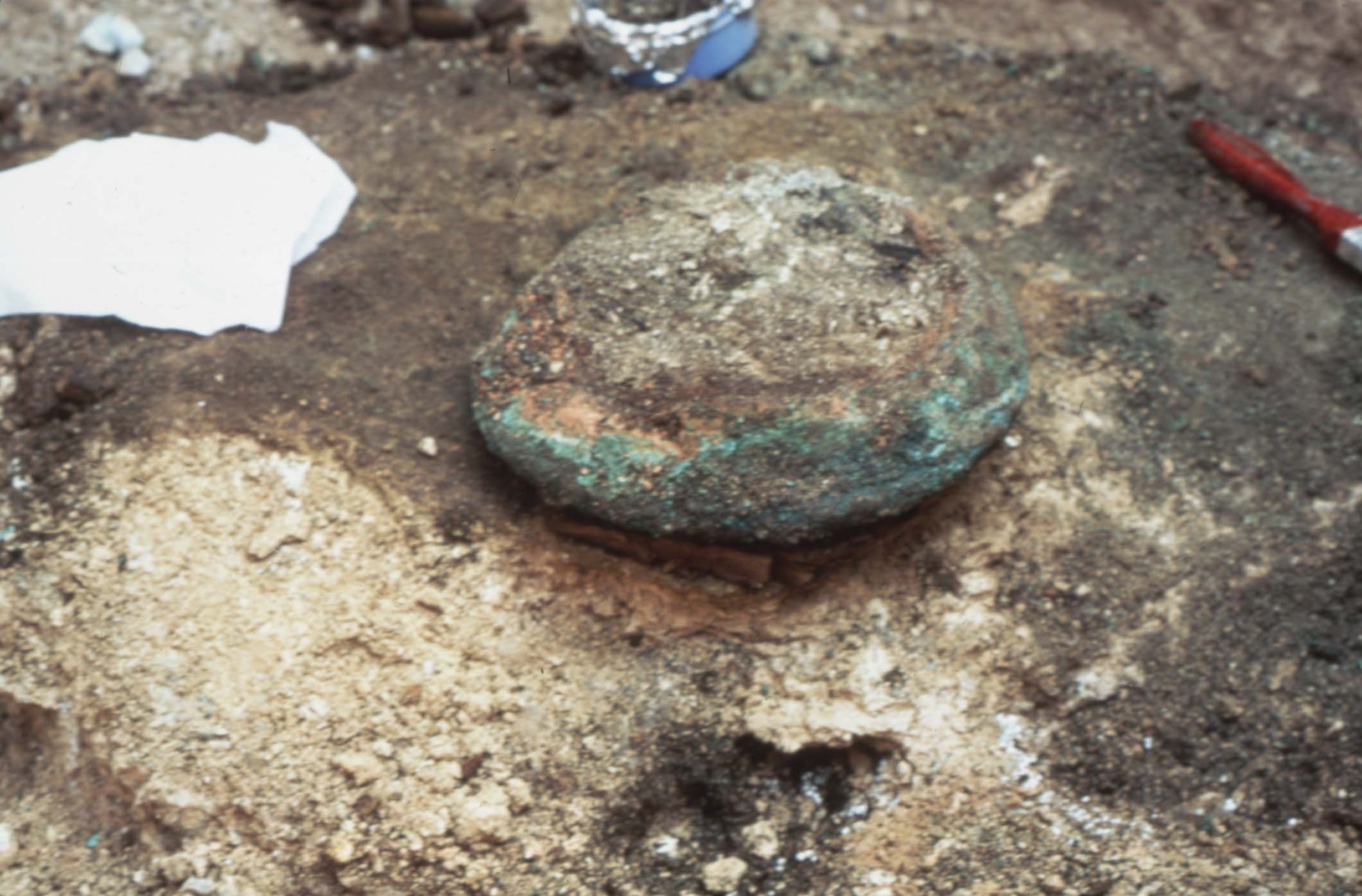 Lefkandi Bronze Amphora During Excavation. The amphora is upside down and surrounded by soil, looks to be mid-excavation. 