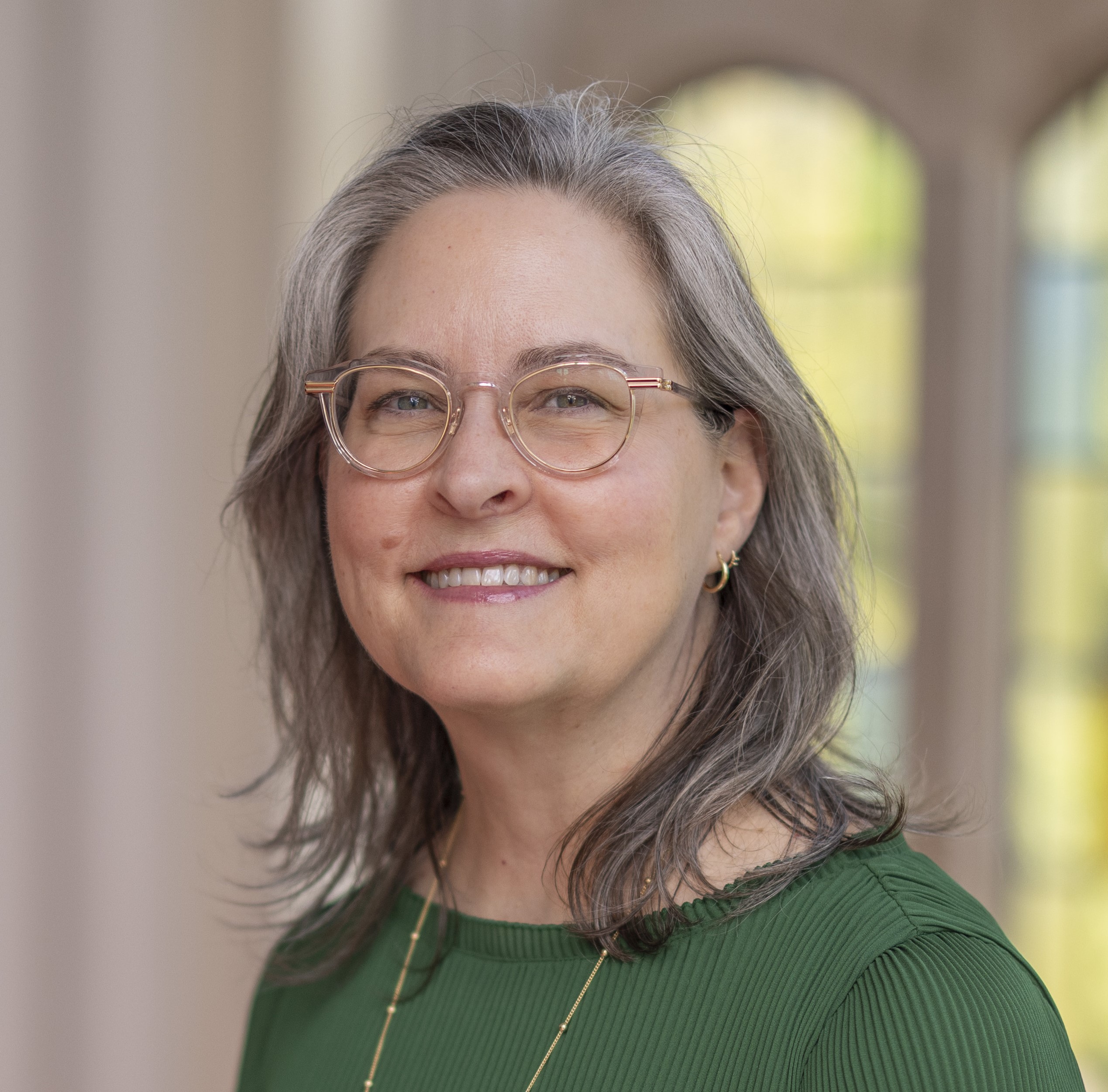 A woman with gray and brown hear, wearing glasses