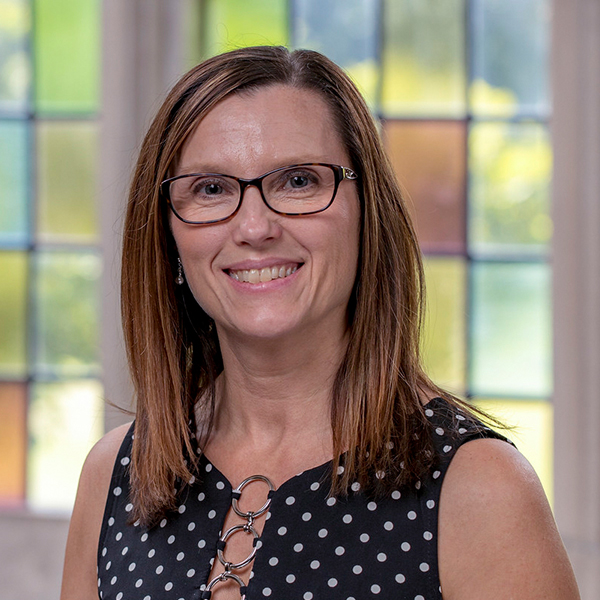Jana Hayes, a woman with shoulder-length red hair and glasses