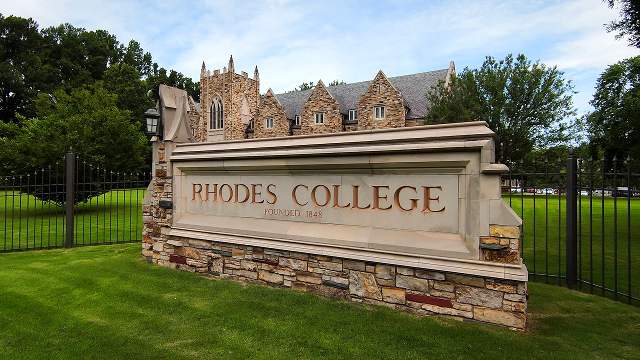 a large stone sign that says Rhodes College