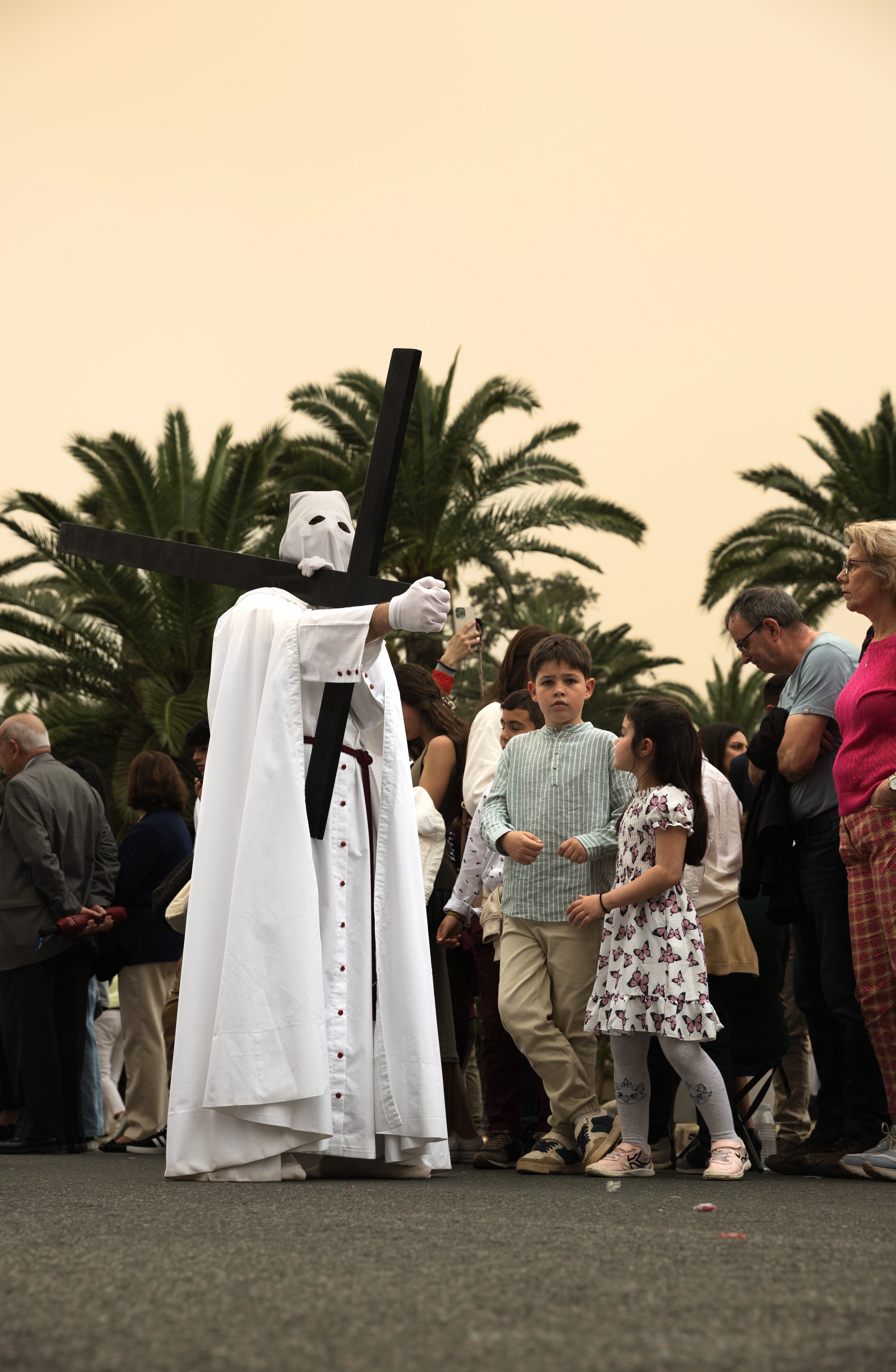 a man in white robes carrying a cross