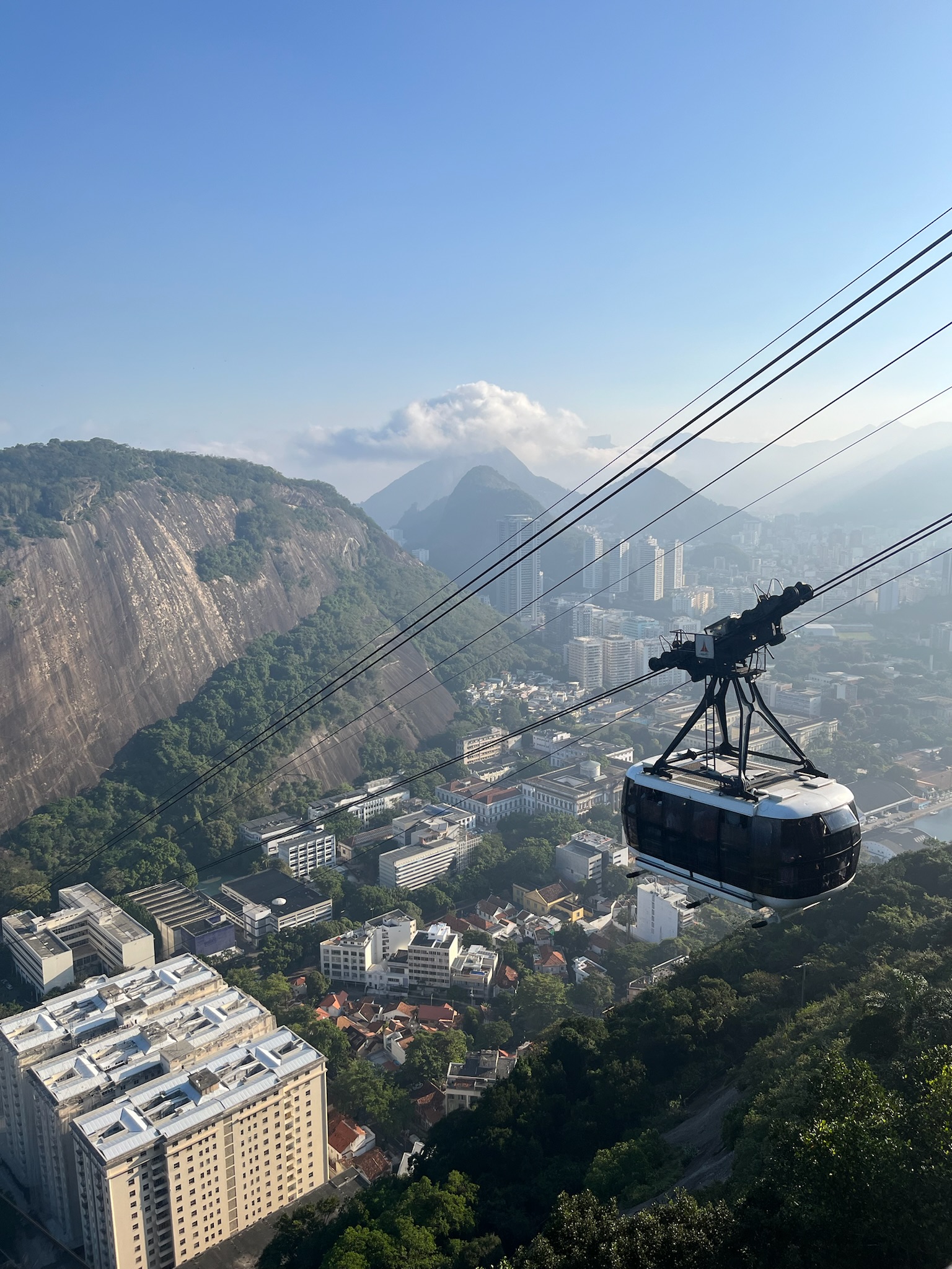 a suspended cable car travels down a steep mountainside