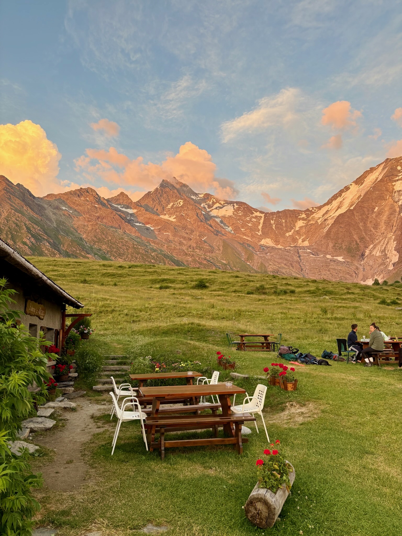 people at a picnic table surrounded by majestic mountains