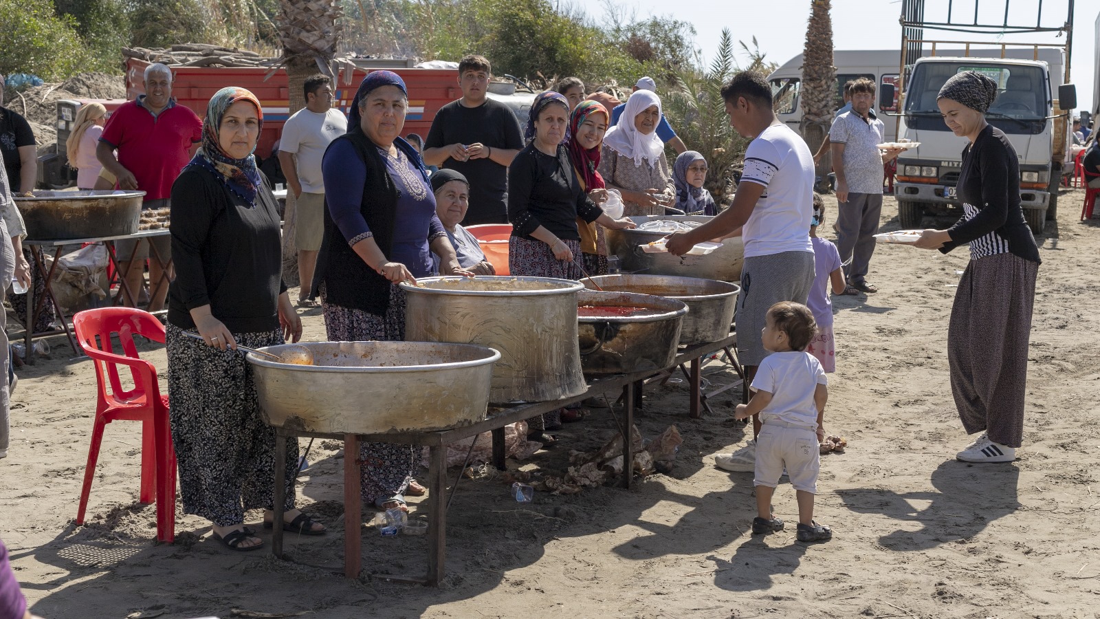 women serving food from large cooking pots