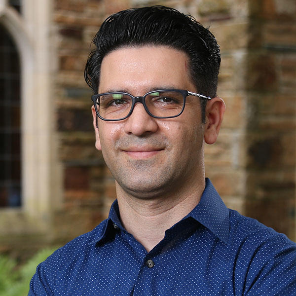 a man with dark hair and glasses