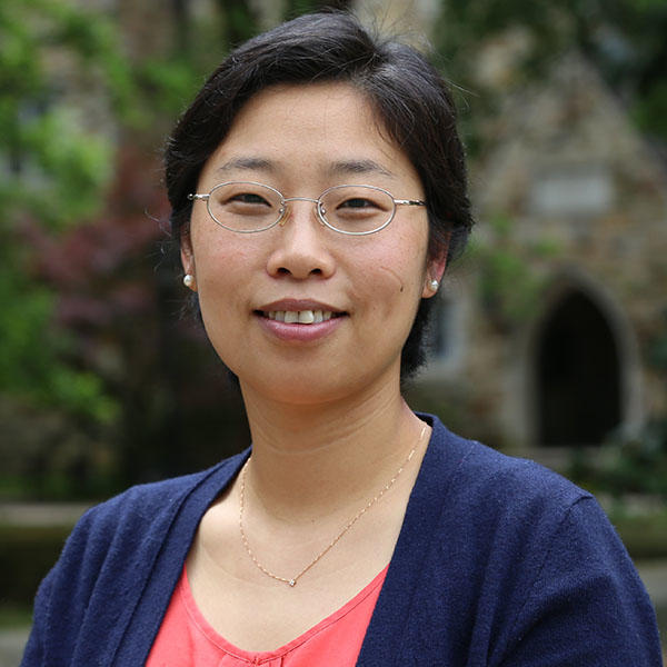 an Asian woman with short hair and glasses