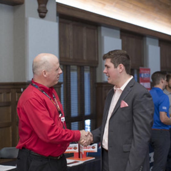 Student shaking employer hand during career fair