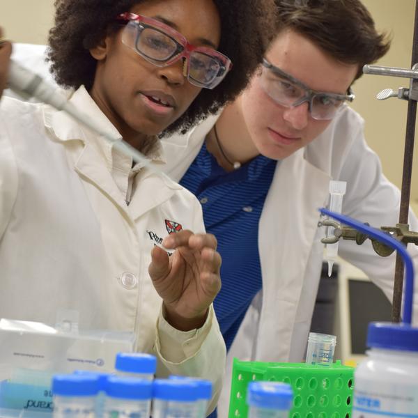 a professor and student in lab coats