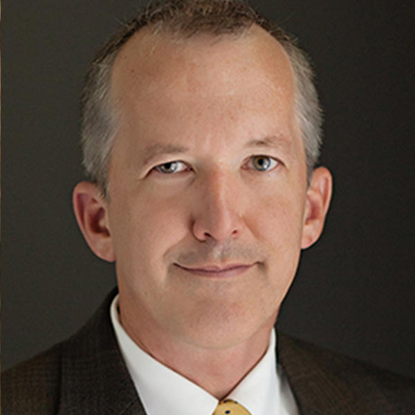 a man with greying hair wearing a dark suit