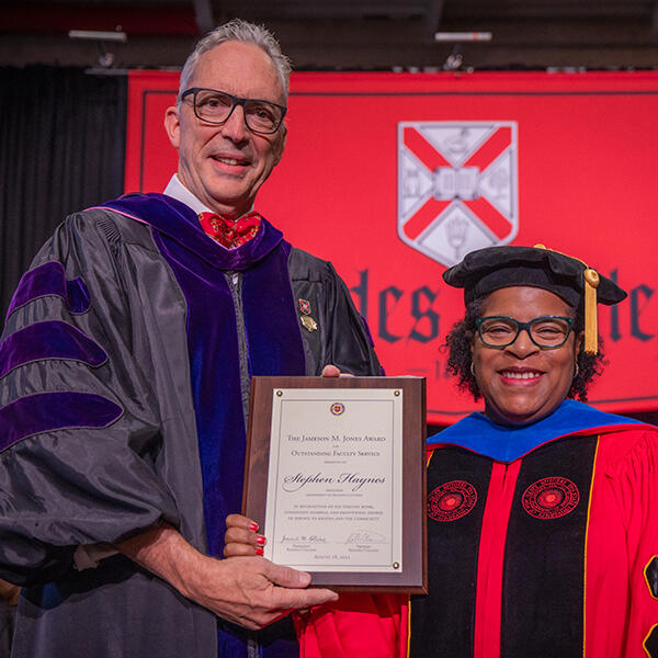 a professor holds an award presented by the Provost