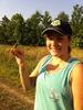 a female student with a baseball cap holds a small bird in her hand