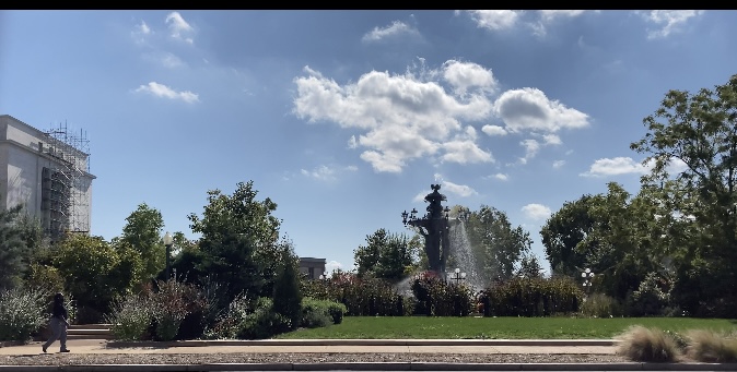 a walkway along a water fountain in a garden