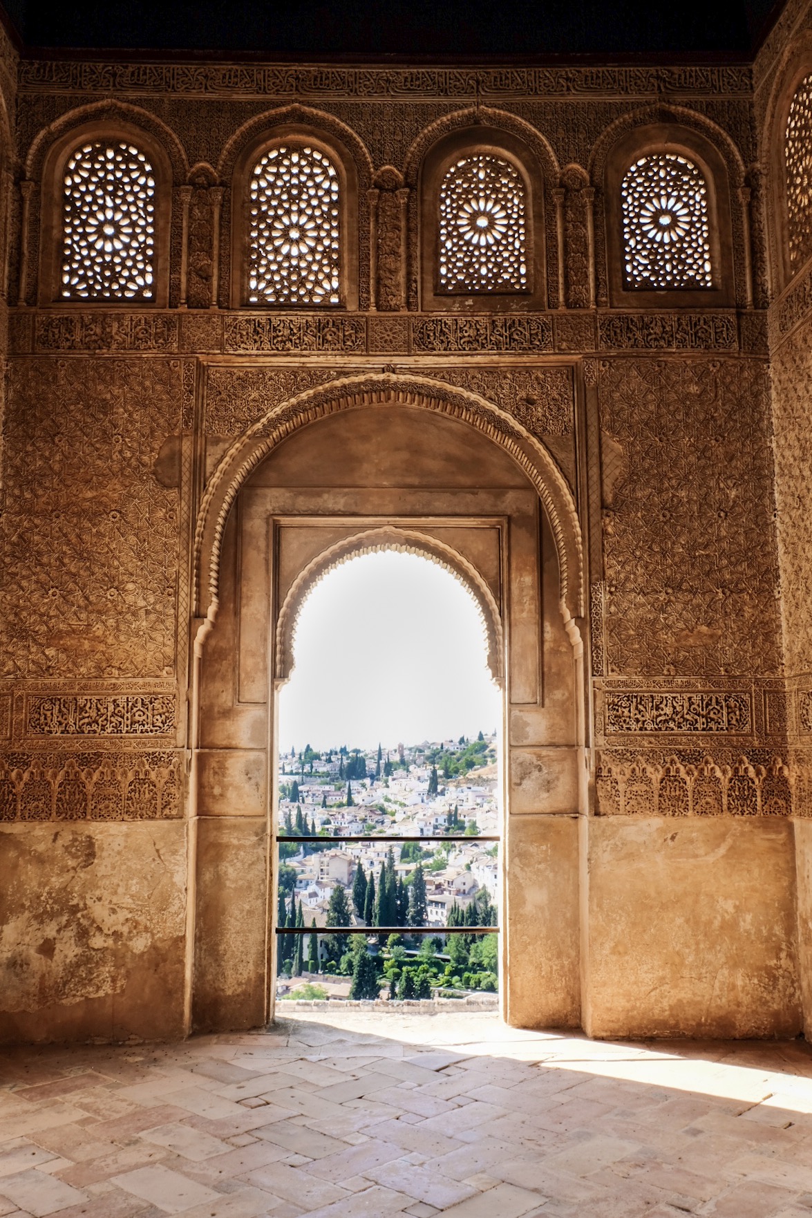 a decorated arched doorway looking out on homes up built up a hillside