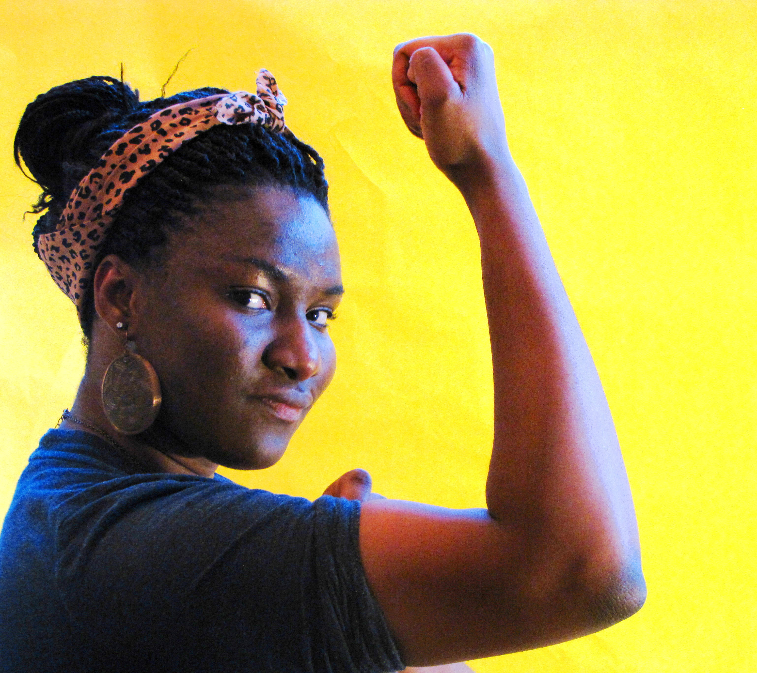 A female student photographed as Rosie the Riveter
