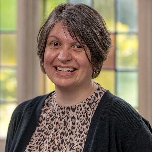 a woman with short hair smiles at the camera