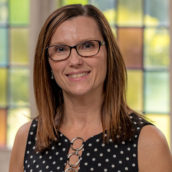 a woman with glasses and shoulder length brown hair